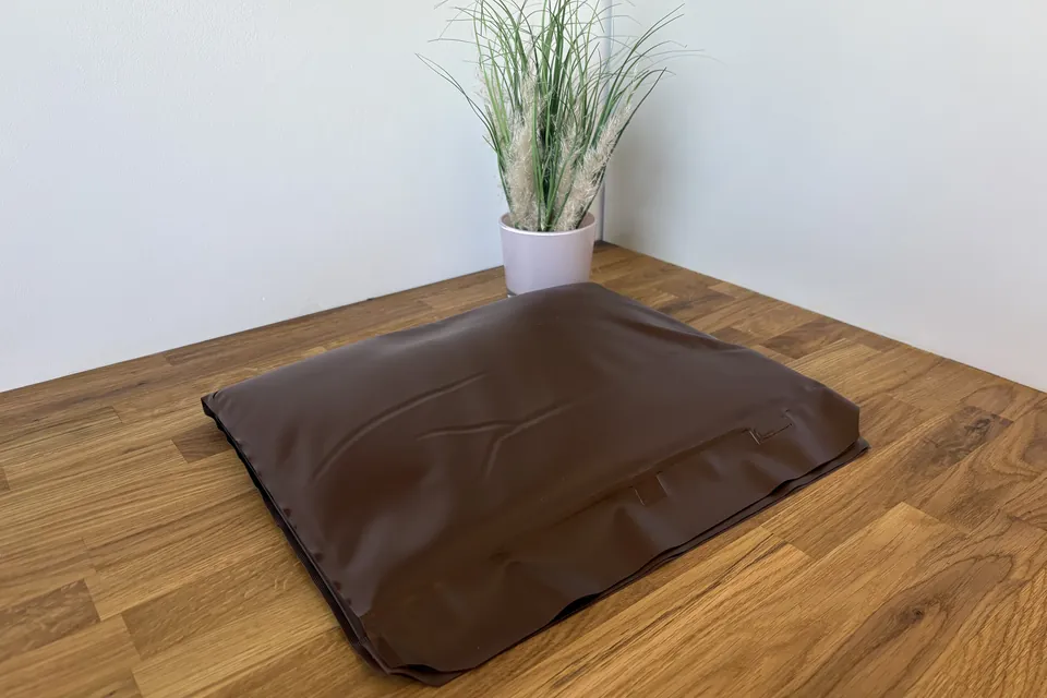 Naturmoorpackung: braune Wärmepackung auf einem Holztisch